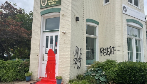 From @MaryMargOlohan on Twitter Picture of red paint on front door and graffiti on walls of Capitol hill CPC